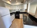 This modern kitchen offers white cabinets, sleek black countertops, and stainless steel appliances at 6800 E Lake Mead Blvd # 2011, Las Vegas, NV 89156