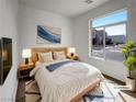 Cozy bedroom with a queen-size bed, nightstands, and a large window with a neighborhood view at 7024 Whispering Falls Dr, North Las Vegas, NV 89084