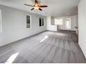 Spacious living room featuring carpet flooring and ample natural light from the large windows at 7024 Whispering Falls Dr, North Las Vegas, NV 89084
