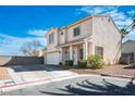 Charming two-story home boasts a lush lawn, an attached two-car garage and is set against a bright blue sky at 7820 Esteem St, Las Vegas, NV 89131