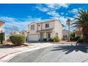 Inviting two-story home with a neatly landscaped yard, complemented by a mature palm tree and a two-car garage at 7820 Esteem St, Las Vegas, NV 89131