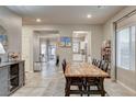 Open dining room with a rustic wood table, six chairs, and views of the kitchen and backyard at 7828 Stone Forest St, North Las Vegas, NV 89084