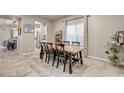 Open dining room with a rustic wood table, six chairs, and views of the kitchen and backyard at 7828 Stone Forest St, North Las Vegas, NV 89084