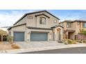 Two-story home featuring a three car garage, stucco siding, tile roof, and a desert landscape at 7828 Stone Forest St, North Las Vegas, NV 89084