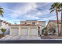 Charming two-story stucco home featuring a three-car garage and desert landscaping during the day at 8032 Marbella Cir, Las Vegas, NV 89128
