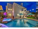 A backyard pool and spa, illuminated by string lights, with a built-in waterfall feature at 8032 Marbella Cir, Las Vegas, NV 89128
