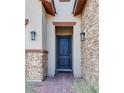 Welcoming front entrance with a dark wooden door, stone accents, stylish outdoor lighting, and brick pathway at 827 Klamath Springs St, Henderson, NV 89011