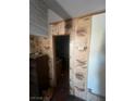 Hallway with dated wood paneling leading to another room in a state of disrepair at 895 Greasewood Ln, Moapa, NV 89025