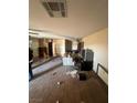 Damaged interior featuring debris-strewn floors, furniture, and a vintage television set at 895 Greasewood Ln, Moapa, NV 89025
