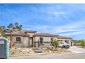 Beautiful single-story home with a three car garage, landscaped yard, and blue sky at 9 Rue Grimaldi Way, Henderson, NV 89011
