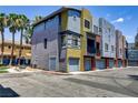 Contemporary townhome with colorful exterior, private garages, and palm tree landscaping at 9050 W Tropicana Ave # 1102, Las Vegas, NV 89147