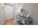 Inviting entryway with decorative console table with flowers, wood floors, and a white front door at 9053 Pearl Cotton Ave, Las Vegas, NV 89149