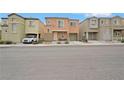 View of multi-story townhomes, each with a unique color and facade at 9053 Pearl Cotton Ave, Las Vegas, NV 89149