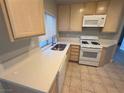 Well-lit kitchen with light wood cabinets, white appliances, and tile flooring at 929 Toro Canyon Ln, Las Vegas, NV 89134