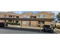 Exterior view of building with assigned covered parking, trimmed landscaping, and neutral colored facade at 1150 N Buffalo Dr # 1015, Las Vegas, NV 89128