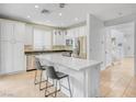 Bright kitchen features white cabinetry, stainless steel appliances, and a center island with seating, perfect for entertaining at 11820 Calle De Sol Dr, Las Vegas, NV 89138