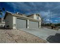 Charming home featuring a two-car garage with a spacious driveway and simple desert landscaping at 172 Cloudcrest Dr, Henderson, NV 89015
