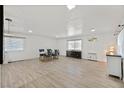 Spacious living room featuring modern wood floors, a large window, and a dining area at 2221 Mohawk St, Las Vegas, NV 89146