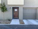 Townhome exterior displaying a private garage, well-maintained landscaping, and a welcoming front entrance at 2775 Atomic Tangerine Way # 4, Las Vegas, NV 89183