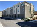 Exterior view of contemporary townhomes featuring a clean design and individual garages for each unit at 2775 Atomic Tangerine Way # 4, Las Vegas, NV 89183
