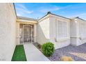 Close-up view of the front entrance featuring a security gate and manicured landscaping at 3015 Extravagant Ave, North Las Vegas, NV 89031