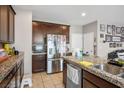 Kitchen includes stainless steel fridge, granite countertops, tile floors, and dark wood cabinets at 4606 Engage St, North Las Vegas, NV 89031
