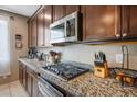 Close up on kitchen counter featuring granite countertops and stainless steel microwave at 4606 Engage St, North Las Vegas, NV 89031