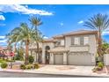 Beautiful two-story home boasts a three-car garage and lush landscaping with desert foliage and palm trees at 4679 El Camino Cabos Dr, Las Vegas, NV 89147