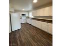 Spacious kitchen featuring white appliances, ample cabinetry, and dark wood-look flooring at 4843 Lana Dr, Las Vegas, NV 89121