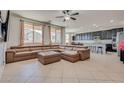 Open-concept living room with tile flooring, large sectional sofa, and abundant natural light at 4908 Desert Lime Ct, Las Vegas, NV 89148