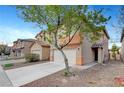 Charming two-story home with a two-car garage, adjacent to neighbor's house on a blue-sky day at 5044 Whistling Acres Ave, Las Vegas, NV 89131