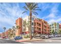 Exterior of multi-story building with desert landscaping, palm trees, and ample parking for residents and guests at 51 E Agate Ave # 205, Las Vegas, NV 89123