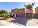 Two-story stucco home with arched entryway, three-car garage, and manicured landscaping at 6403 Brandon Hills Ct, Las Vegas, NV 89139
