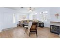 Cozy living room with a fireplace, large windows, and light wood flooring at 802 Blue Springs Dr, Henderson, NV 89002