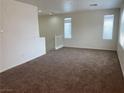 Spacious living room featuring new carpet and ample natural light from large windows at 8187 Deadwood Bend Ct, Las Vegas, NV 89178