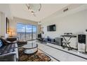 Sunlit living room with a leather sofa, decorative rug, and floor-to-ceiling windows showcasing scenic mountain views at 8255 Las Vegas Blvd # 1504, Las Vegas, NV 89123