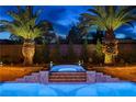 Inviting pool and spa area surrounded by lush landscaping and mature palm trees at 9475 Windham Heights Ct, Las Vegas, NV 89139