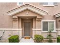 Charming front entrance featuring a neutral-toned door, manicured bushes, and a well-kept lawn at 10086 Aspen Rose St # 101, Las Vegas, NV 89183