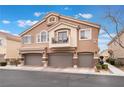 Inviting townhome with a private balcony and three-car garage spaces, complemented by manicured landscaping at 10086 Aspen Rose St # 101, Las Vegas, NV 89183