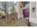 Charming front porch with double doors, lovely stone water feature, and sitting area at 1465 Via Savona Dr, Henderson, NV 89052