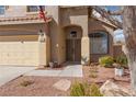 Welcoming home exterior featuring a double door entry, a garage and xeriscaping at 1501 Scenic Peak St, Las Vegas, NV 89144