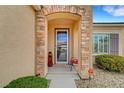 Inviting front porch with stone archway and decorative accents creating a warm welcome to the front door at 2208 Sawtooth Mountain Dr, Henderson, NV 89044