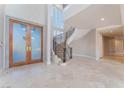 Elegant foyer with decorative double doors, curved staircase, and travertine floors, setting a grand entrance at 2221 Glenbrook Way, Las Vegas, NV 89117