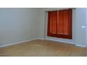 A brightly lit living room featuring laminate flooring and a large window with orange curtains at 2711 Sesame Dr, Las Vegas, NV 89142