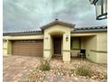 Beautiful single story home with a tan exterior, brown garage door, and brick paver landing at 2790 Chetco River St, Laughlin, NV 89029