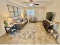 Open living room with neutral decor, ceiling fan, tile floors, and comfortable seating at 2790 Chetco River St, Laughlin, NV 89029