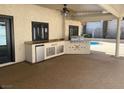 Inviting outdoor kitchen area complete with a built-in grill, mini fridge, and ample counter space for entertaining at 3417 Iberia St, Las Vegas, NV 89146