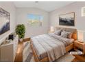 Cozy bedroom with a neutral color scheme, wooden furniture, and a large window at 350 Loma Marsh Ct, North Las Vegas, NV 89084