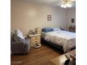 Neutral bedroom with wood laminate flooring, ceiling fan, and comfortable furnishings at 3748 E Hacienda Ave, Las Vegas, NV 89120