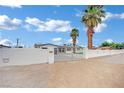 Gated property with a white block wall, a decorative gate, and mature palm trees at 7060 S Valley View Blvd, Las Vegas, NV 89118